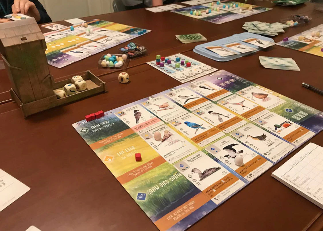 Board game setup on a table with various game pieces and cards.